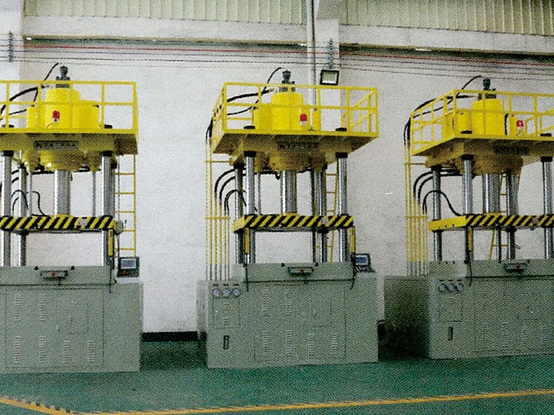 Two hydraulic presses with yellow upper platforms in the factory