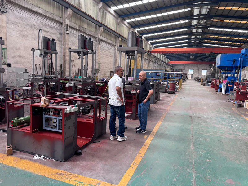 People beside hydraulic machinery on a factory floor