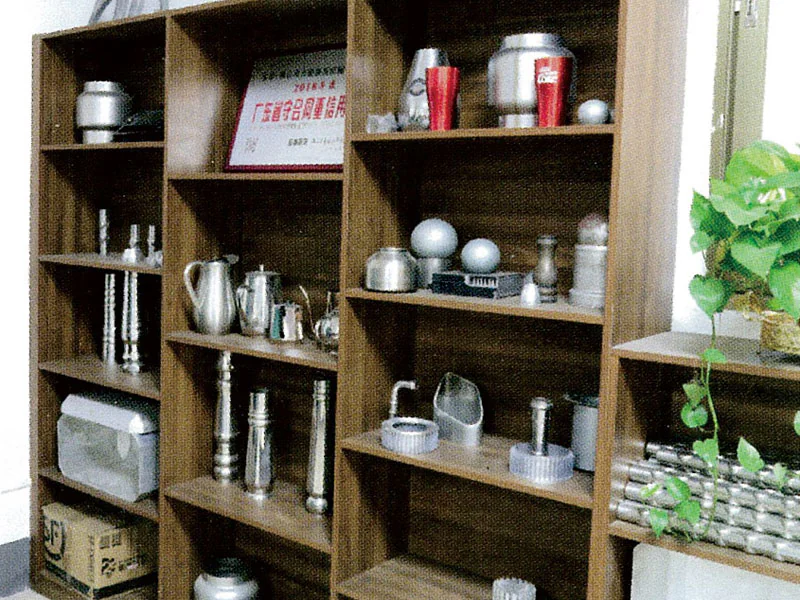 Shelves displaying formed metal bowls, kettles and containers