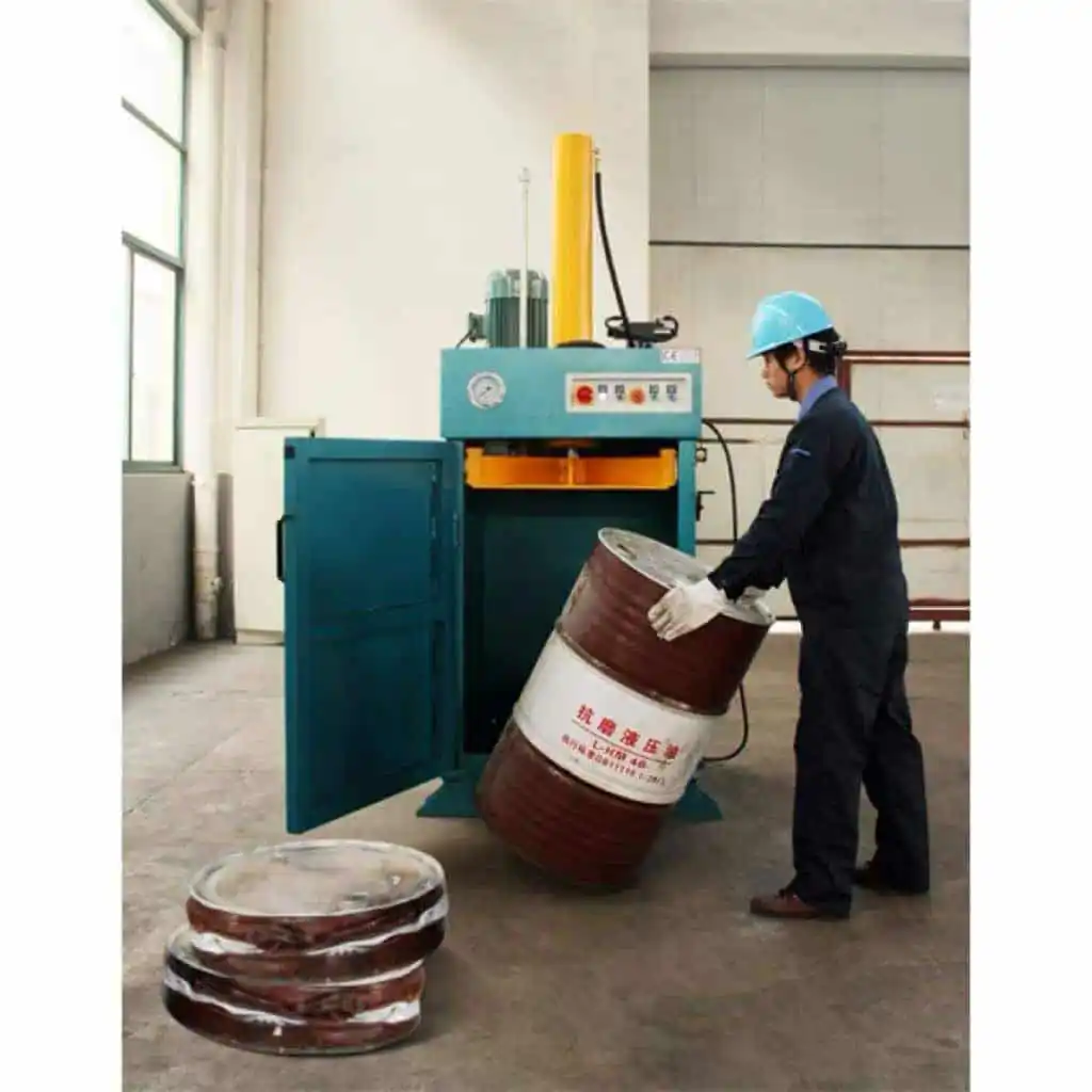 Operator loading a metal drum into a hydraulic baler