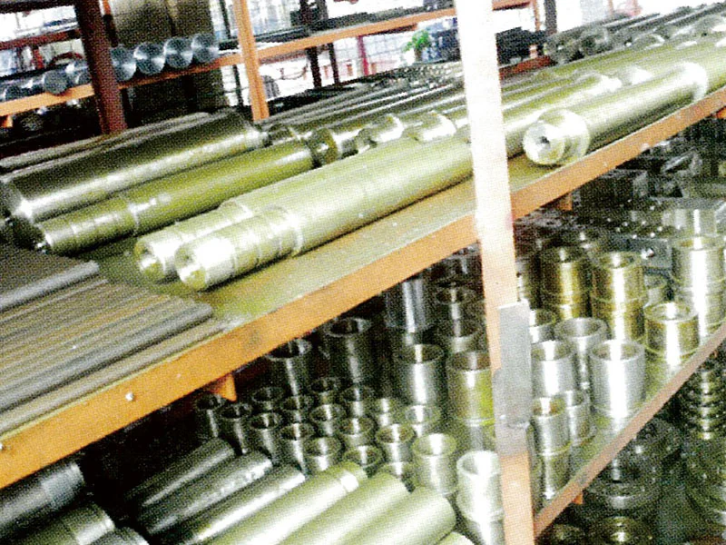 Rows of metal cylinders and machined components in storage