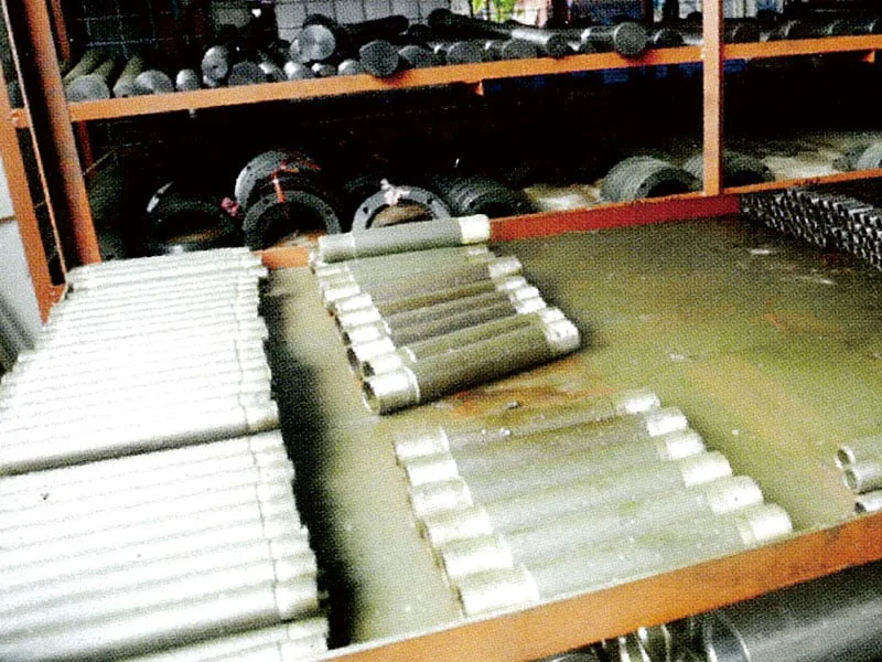 Machined metal cylinders and components on storage shelves